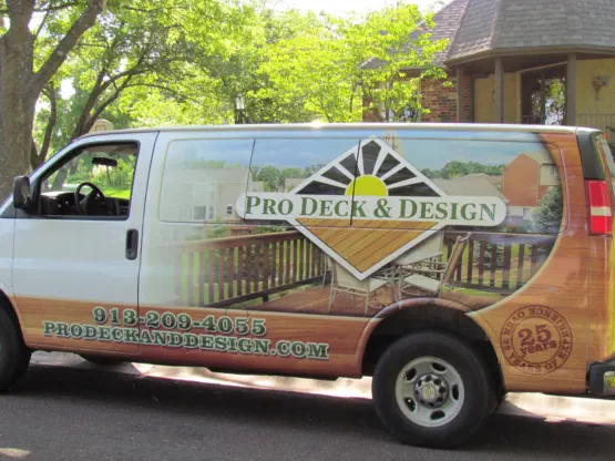 Professional service van for Pro Deck & Design in Kansas City displaying company logo, custom deck portfolio images, 30+ years of experience badge, website URL, and local phone number 913-209-4055 serving Johnson, Wyandotte, and Leavenworth Counties