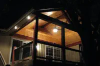 Elegant covered deck with cedar tongue and groove ceiling, recessed lighting, and black railings built by Pro Deck & Design in Kansas City, creating a perfect evening entertainment space for year-round enjoyment in all Wyandotte County weather conditions