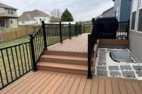 Modern composite deck with black aluminum railings installed by Pro Deck & Design in Kansas City, featuring built-in outdoor kitchen area, custom steps, and durable low-maintenance decking perfect for Leavenworth County weather conditions