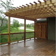 Custom cedar deck with attached pergola designed and built by Pro Deck & Design in Kansas City, featuring quality craftsmanship, partial shade coverage, and panoramic view of landscaped yard in Wyandotte County