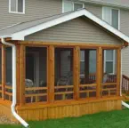 Custom cedar screened porch built by Pro Deck & Design in Kansas City, featuring quality craftsmanship with wooden framing, full screening for bug-free enjoyment, and seamless integration with existing Johnson County home