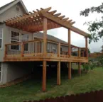 Custom elevated cedar deck with attached pergola designed and built by Pro Deck & Design in Kansas City, featuring multi-level construction for sloped yards and quality craftsmanship for long-lasting outdoor living spaces in Leavenworth County
