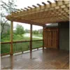 Custom cedar deck with attached pergola designed and built by Pro Deck & Design in Kansas City, featuring quality craftsmanship, partial shade coverage, and panoramic view of landscaped yard in Wyandotte County