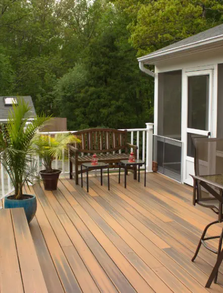 Custom composite deck with attached screened porch built by Pro Deck & Design in Kansas City, featuring premium low-maintenance decking, outdoor living furniture, and tranquil wooded privacy perfect for relaxation in Johnson County homes