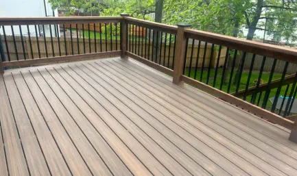 Newly installed composite deck in Kansas City with premium weather-resistant materials, featuring custom wooden railings with metal balusters and expert craftsmanship by local Kansas contractors specializing in durable outdoor living spaces