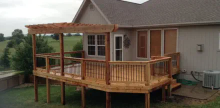 Custom elevated cedar deck with matching pergola in Kansas City featuring quality pressure-treated lumber, professional installation, and expert design perfect for Kansas homes with scenic views and outdoor entertainment needs
