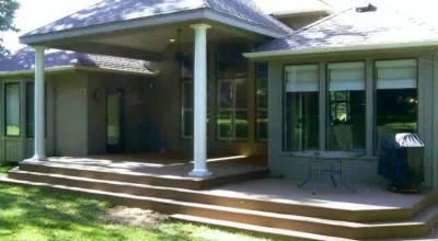 Custom covered porch addition in Kansas City featuring professional roof integration, quality wooden steps, and expert construction by experienced Kansas contractors specializing in premium outdoor living enhancements