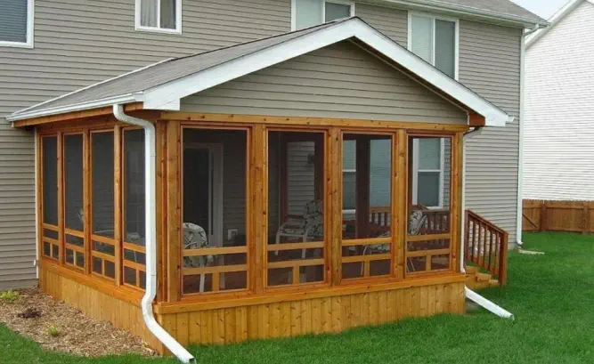 Custom cedar screened porch built by Pro Deck & Design in Kansas City, featuring quality craftsmanship with wooden framing, full screening for bug-free enjoyment, and seamless integration with existing Johnson County home