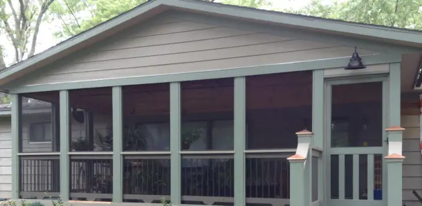 Custom screened porch addition with full-view screens and gabled roof design built by Pro Deck & Design in Kansas City, providing bug-free outdoor living space with professional landscaping for Leavenworth County homeowners