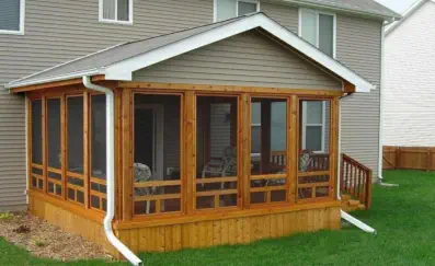 Custom cedar screened porch built by Pro Deck & Design in Kansas City, featuring quality craftsmanship with wooden framing, full screening for bug-free enjoyment, and seamless integration with existing Johnson County home