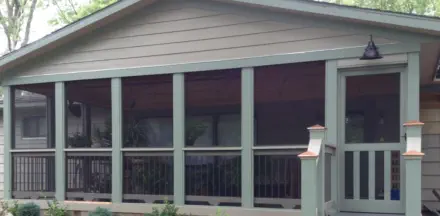 Custom screened porch addition with full-view screens and gabled roof design built by Pro Deck & Design in Kansas City, providing bug-free outdoor living space with professional landscaping for Leavenworth County homeowners