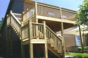 Elevated pressure-treated wood deck with professional staircase and railings built by Pro Deck & Design in Wyandotte County, showcasing durable outdoor living solutions for Kansas City homeowners